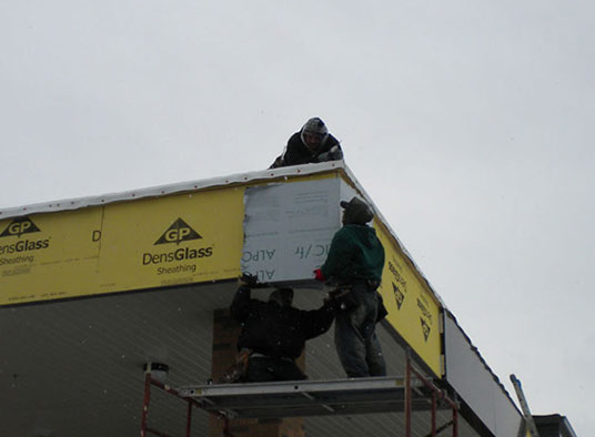 Commercial roofing crew installing insulation board